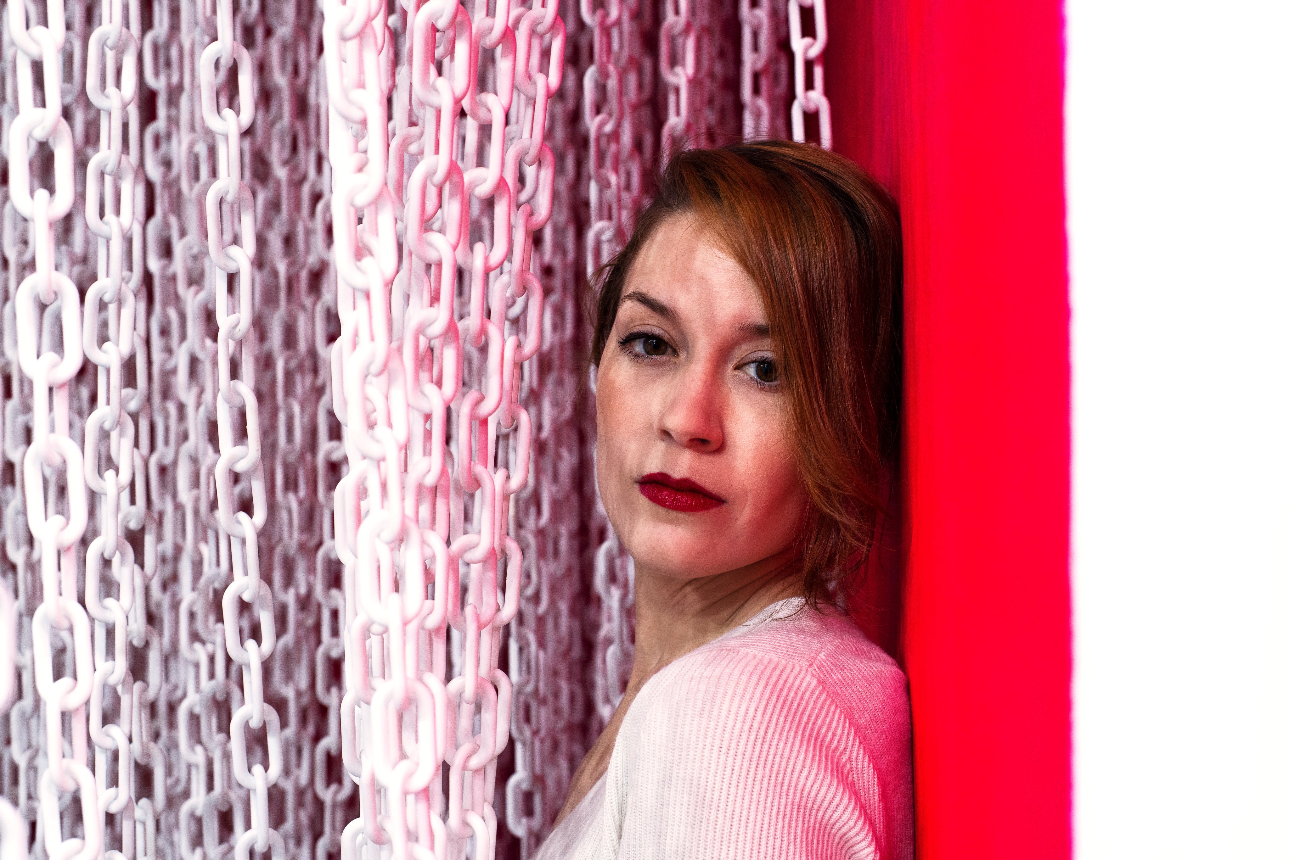 files/woman-sandwiched-between-a-red-wall-and-a-curtain-of-white-chains.jpg